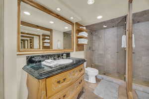 Bathroom with vanity, toilet, and a shower with door