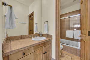 Full bathroom featuring bath / shower combo with glass door, toilet, tile patterned flooring, and vanity