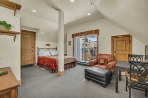 Carpeted bedroom featuring access to outside and vaulted ceiling