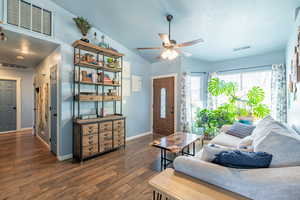 Living room featuring ceiling fan, a textured ceiling, dark hardwood / wood-style floors, and lofted ceiling