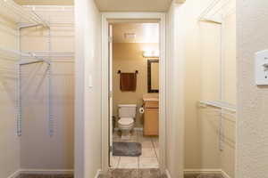 Interior space with toilet, tile patterned floors, and vanity