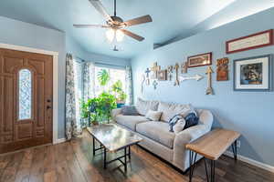 Living room with dark hardwood / wood-style floors and ceiling fan