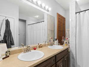 Bathroom with vanity and a shower with shower curtain