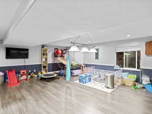 Rec room featuring wood-type flooring and a textured ceiling