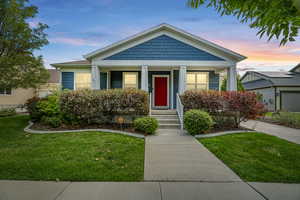 Bungalow-style home with covered porch and a lawn