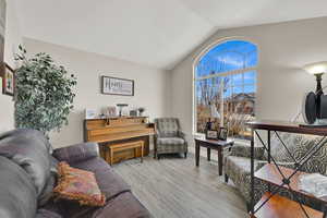 Living room with light hardwood / wood-style flooring and lofted ceiling