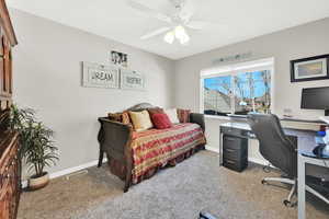 Carpeted home office with ceiling fan