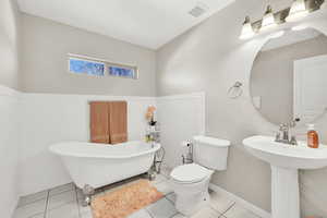 Bathroom with sink, toilet, tile patterned floors, and a bathing tub