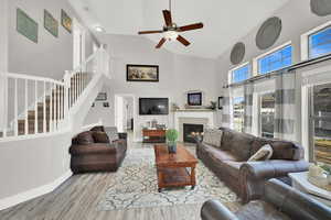 Living room with high vaulted ceiling, light hardwood / wood-style flooring, and ceiling fan