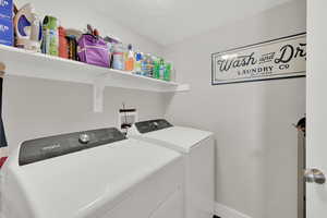 Clothes washing area with separate washer and dryer and a textured ceiling