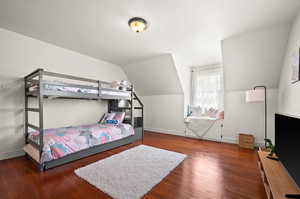 Bedroom featuring dark hardwood / wood-style flooring and lofted ceiling