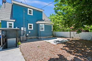 Backyard featuring basement walkout, patio, and central AC unit