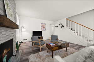 Living room with a fireplace and wood-type flooring