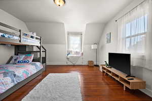 Bedroom with lofted ceiling and dark hardwood / wood-style flooring