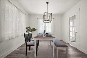 Dining room featuring dark wood-type flooring and a chandelier