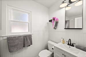 Bathroom featuring toilet, a shower with curtain, and vanity