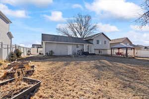 Back of house featuring a gazebo and a yard