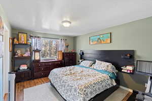 Bedroom with light hardwood / wood-style floors and a textured ceiling