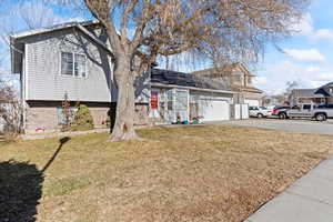 View of front of home with a garage and a front lawn