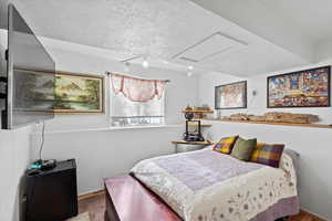 Bedroom featuring track lighting and a textured ceiling