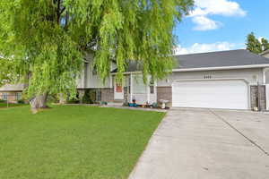 View of front of property with a front yard and a garage