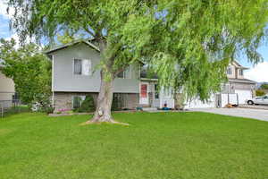 Tri-level home with a front lawn and a garage