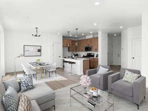 Living room featuring an inviting chandelier, sink, and light hardwood / wood-style flooring