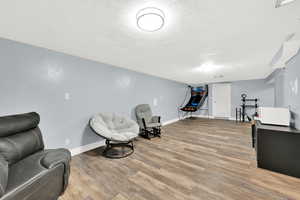 Living area featuring hardwood / wood-style floors and a textured ceiling