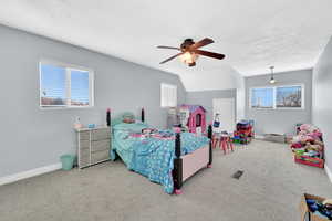 Bedroom with ceiling fan, a textured ceiling, carpet floors, and lofted ceiling