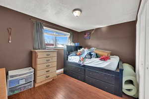 Bedroom featuring wood-type flooring and a textured ceiling