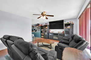 Living room featuring a textured ceiling, dark hardwood / wood-style floors, and ceiling fan