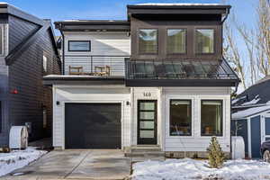 View of front facade with a balcony and a garage