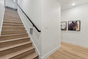 Stairway featuring hardwood / wood-style flooring