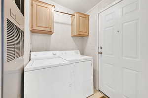 Laundry area with cabinets, separate washer and dryer, and a textured ceiling