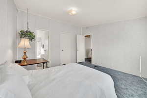 Bedroom featuring dark carpet and a textured ceiling