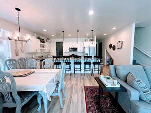 Dining area featuring sink, light hardwood / wood-style floors, a textured ceiling, and an inviting chandelier