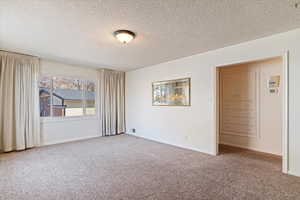 Spare room featuring a textured ceiling and carpet