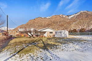 Exterior space with a mountain view, a yard, and a storage unit