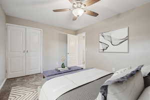 Carpeted bedroom with a closet and ceiling fan