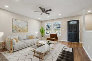 Living room with light hardwood / wood-style floors and ceiling fan