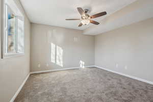 Empty room featuring ceiling fan and carpet