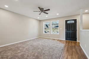 Living room with light hardwood / wood-style floors and ceiling fan