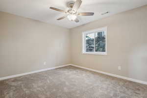 Carpeted empty room featuring ceiling fan