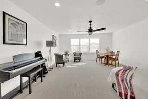 Sitting room with ceiling fan and light colored carpet