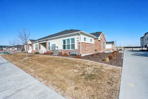 Ranch-style home featuring a front yard and central AC unit