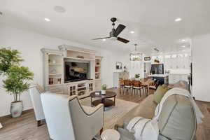 Living room with ceiling fan, light hardwood / wood-style flooring, and a textured ceiling