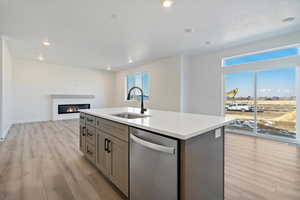 Kitchen featuring a kitchen island with sink, a healthy amount of sunlight, dishwasher, and sink