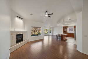 Unfurnished living room with ceiling fan, light hardwood / wood-style floors, a tile fireplace, and sink