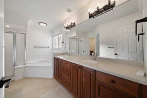 Bathroom with plus walk in shower, ornamental molding, tile patterned floors, and vanity