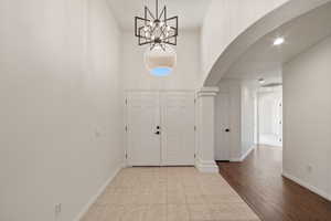 Foyer entrance with light tile patterned floors and a high ceiling